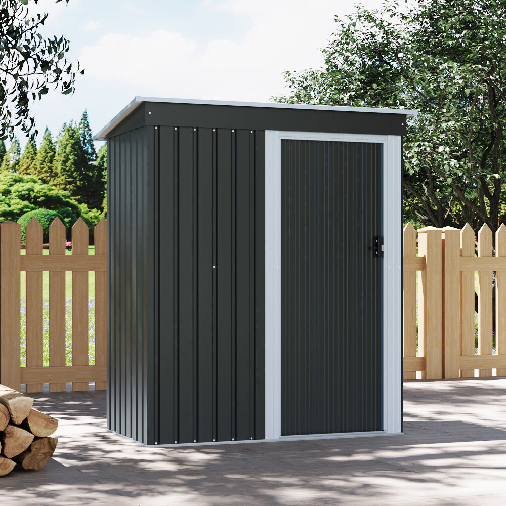 Compact 6x3ft backyard metal storage shed – lockable charcoal black shed blending into garden environment