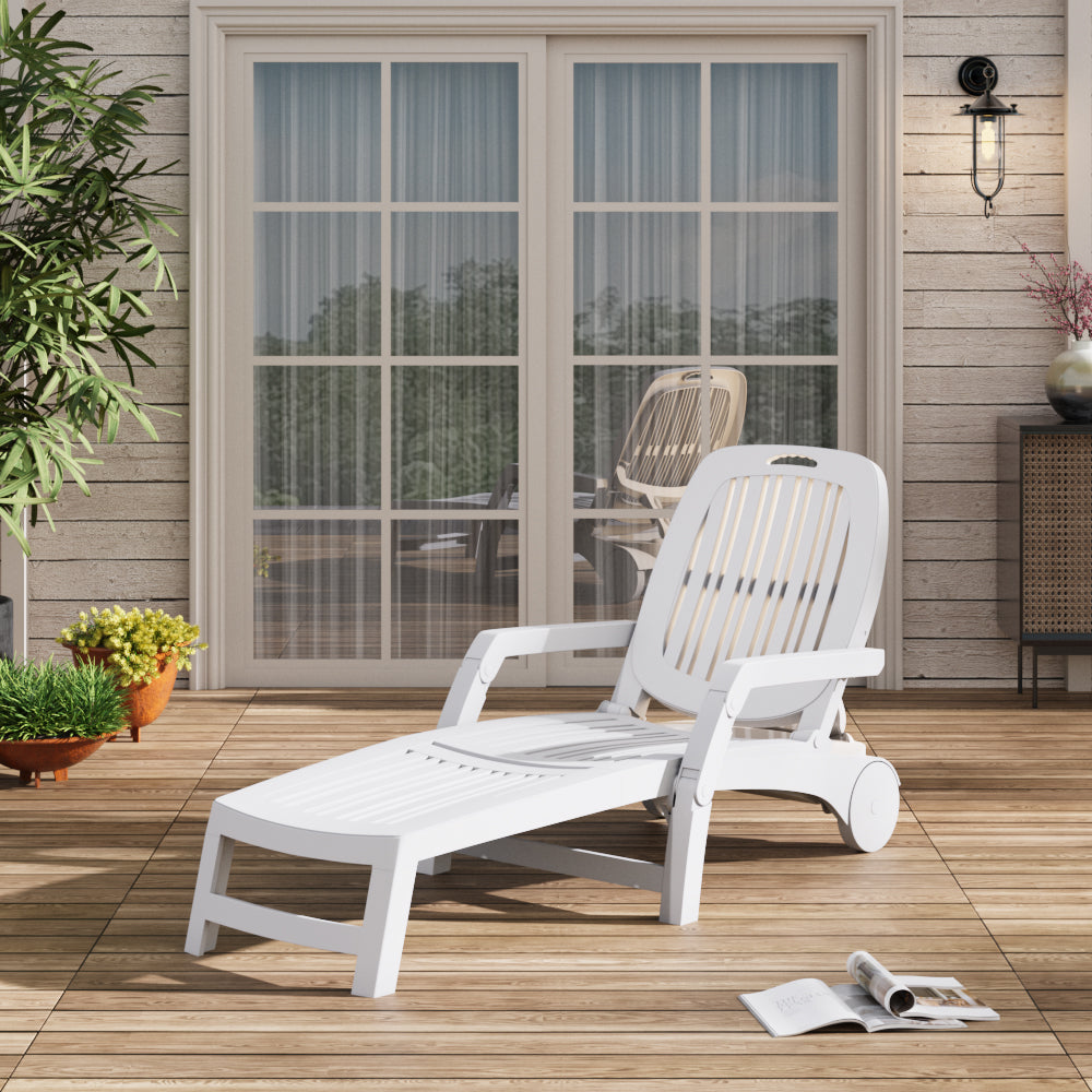 White reclining garden chair on patio deck with flowers and side table